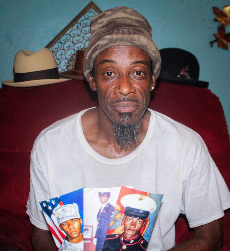 St. Louis client, Christopher, sitting indoors with a camouflage hat and a shirt with images of him in uniform