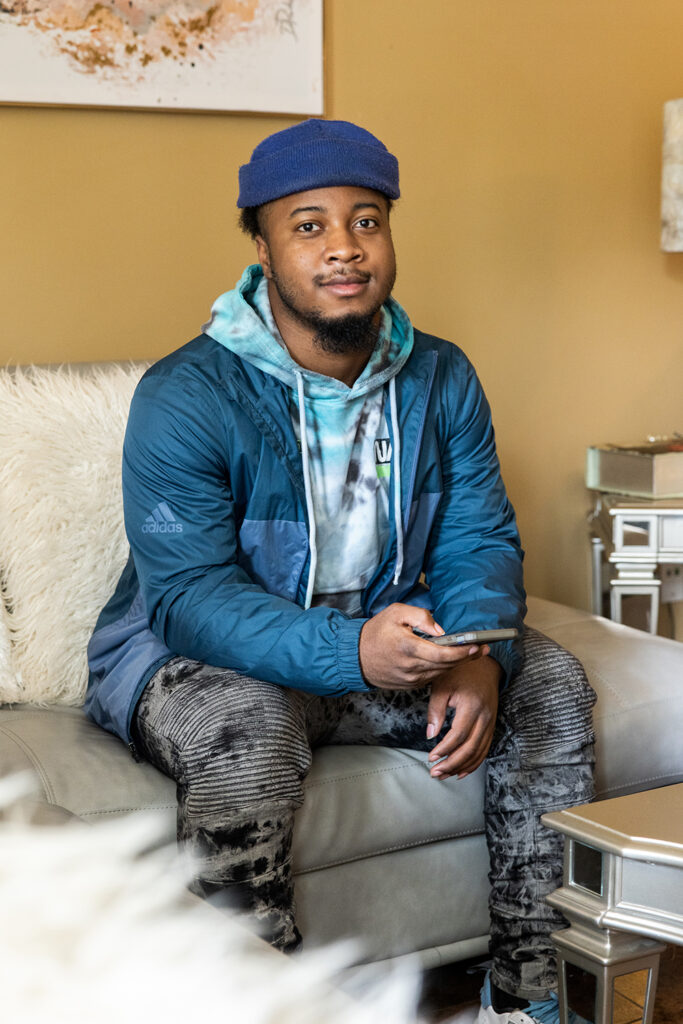 St. Louis Client sitting on a couch in a jacket and hat