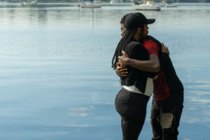 Bail Project client, Linda, hugging her son, Henry, in front of a lake.