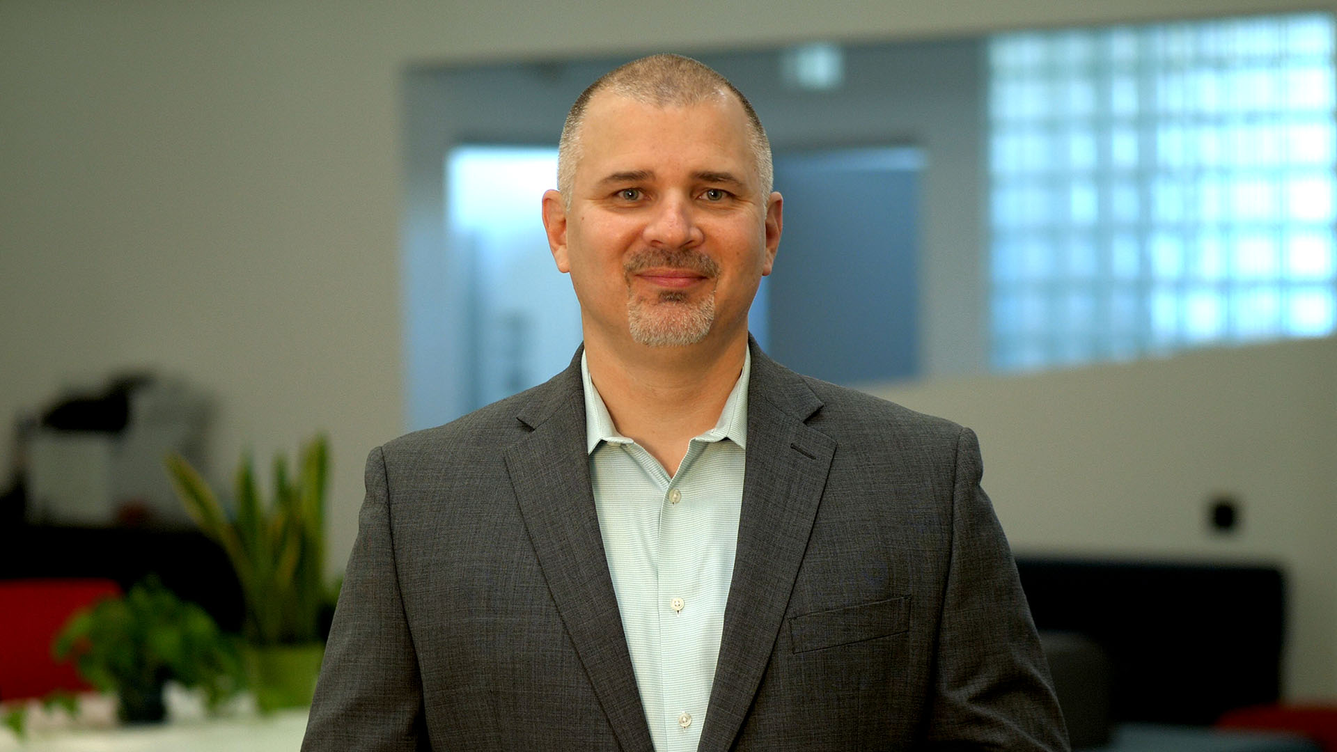 a man in a suit standing in an office.