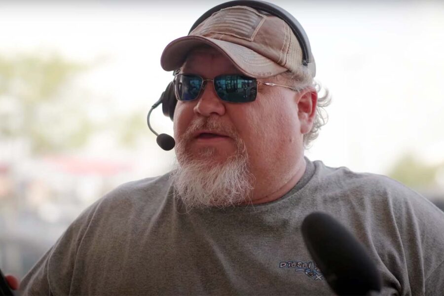 Discussing the cash bail system, a bearded Kentucky resident wearing a headset and sunglasses speaks into a microphone