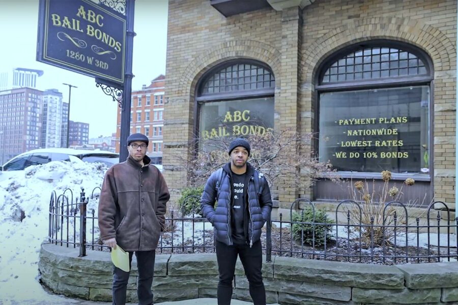 Two individuals standing in front of "ABC Bail Bonds"