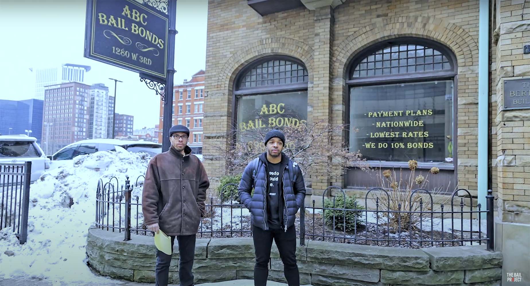 Two individuals standing in front of "ABC Bail Bonds"