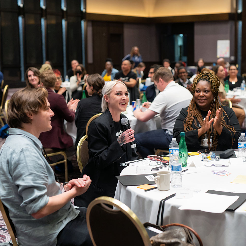 A group of people sitting around a table discussing social justice.