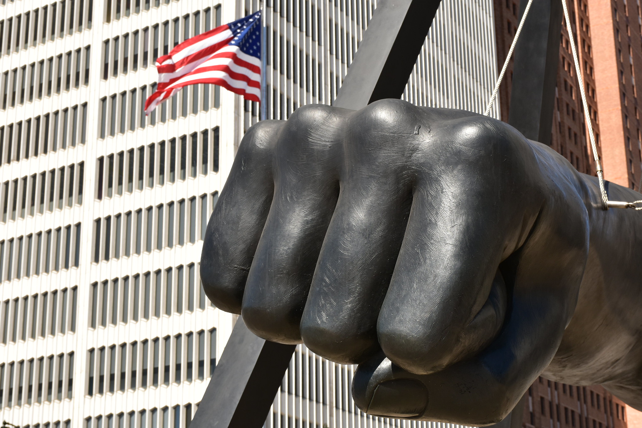 a statue of a fist with an american flag in the background.