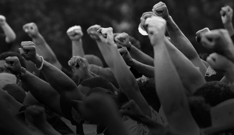 a group of people holding up their fists in the air.