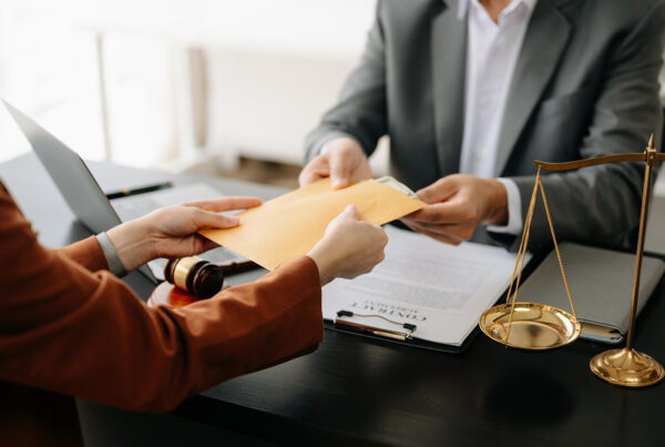 Someone handing a yellow envelope of money over A desk