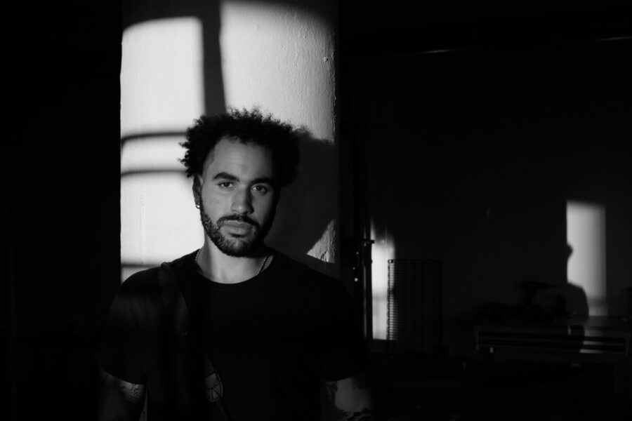 Bail Project supporter Isaac Wright, against a pillar with shadows, black and white