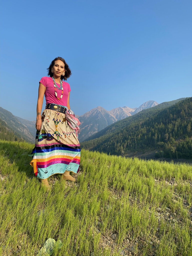 Bail Project client, Ontequa, in colorful clothing standing in the sunshine in the mountains
