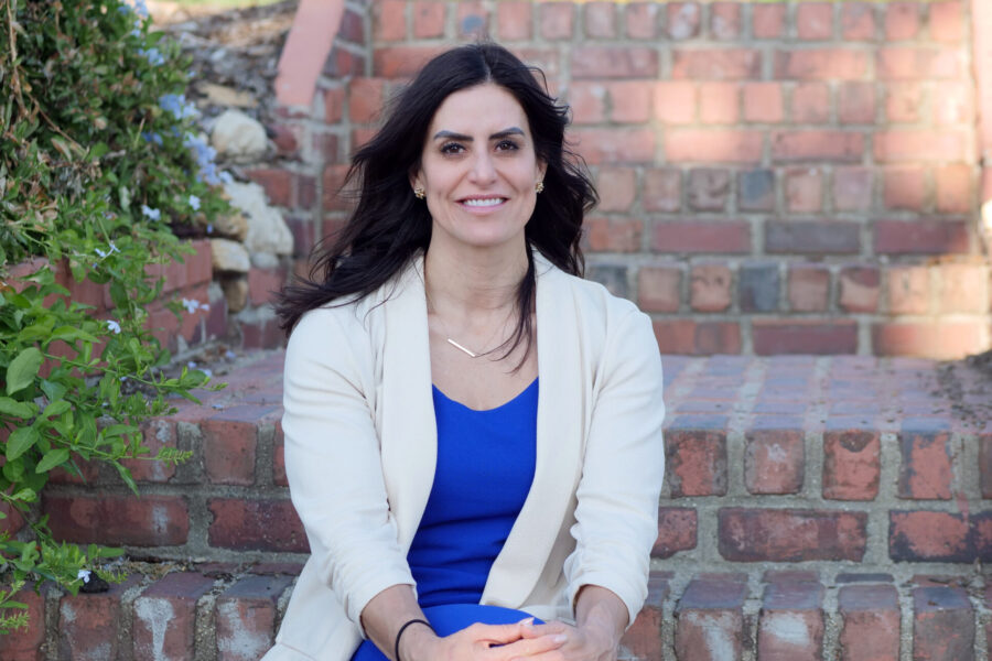 Bail Project Philanthropic Director Kristina Justiniano smiling, sitting on brick steps outside