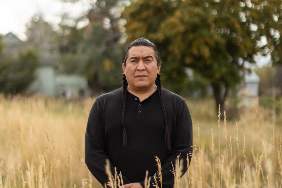 Bail Project client Antoine standing outside amongst tall grasses